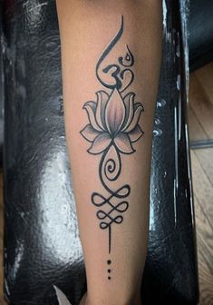 a woman's leg with a lotus tattoo on it and an arrow in the middle