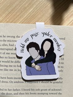 a bookmark with an image of two people hugging each other on top of a book