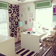 a home office with zebra rugs and colorful wallpaper on the walls, along with two chairs