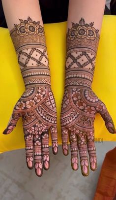 two hands with henna tattoos on them