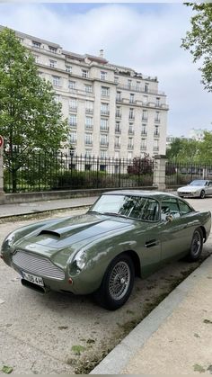 an old green car parked on the side of the road