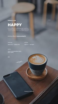 a cup of coffee sitting on top of a wooden table next to a cell phone