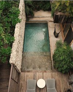 an aerial view of a small pool with two chairs