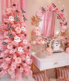 a pink christmas tree in front of a mirror with decorations on the top and bottom