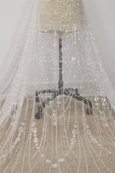 a white veil with beads hanging from it