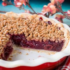 a close up of a pie on a plate with crumbled crust and berries