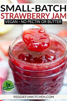 small batch strawberry jam in a glass jar with a spoon sticking out of the jar