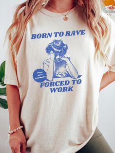 Tee with retro man design here ➡️: https://www.etsy.com/listing/1844202641/born-to-rave-forced-to-work-shirt-unisex? Express your inner rave lover with this playful "Born to Rave, Forced to Work" shirt. Featuring a vintage-style illustration of a woman looking frustrated and a quirky slogan, this tee is perfect for anyone who lives for raves and festivals but has to deal with the daily grind. The retro blue print on a cream-colored shirt adds a unique touch, combining humor and style with a subt Rave Style Cotton T-shirt With Crew Neck, Rave Cotton Crew Neck Tops, Cotton Rave Crew Neck Top, Cotton Rave Top With Crew Neck, Cotton Crew Neck T-shirt For Rave, Cotton Crew Neck Rave Tops, Rave Cotton Top With Letter Print, Rave Cotton Tops With Letter Print, Cotton Graphic Print Rave Tops