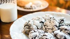 chocolate crinkle cookies on a white plate next to a glass of milk