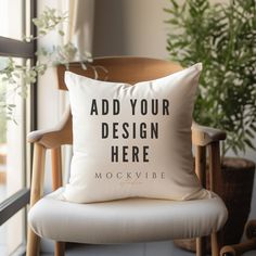 a white pillow sitting on top of a wooden chair next to a potted plant