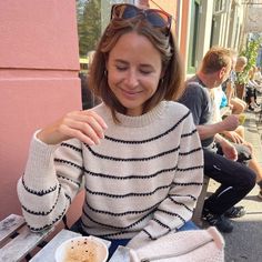 a woman sitting at a table eating food