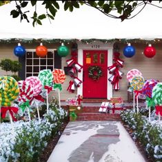 a house decorated for christmas with candy canes on the front lawn and decorations around it