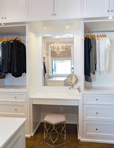 a dressing room with white cabinets and drawers