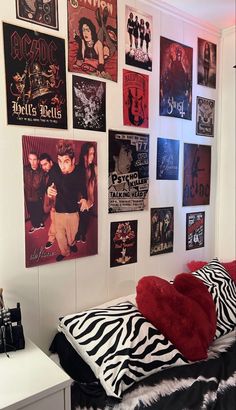 a bedroom with posters on the wall and a zebra print bed spread across the room