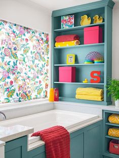 a bath room with a tub and a shelf filled with colorful towels on it's sides