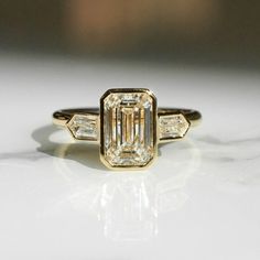 an emerald cut diamond ring with three baguets