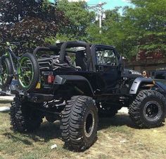 a black jeep parked on top of a grass covered field