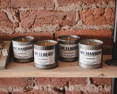 three candles sitting on top of a wooden shelf