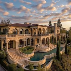 an aerial view of a mansion with a pool in the foreground and stairs leading up to it