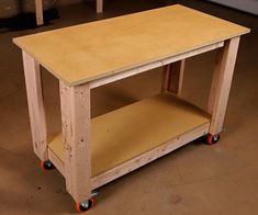 a small wooden table with wheels on the bottom and one shelf below it that is empty