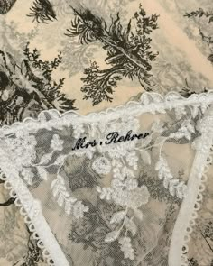 an embroidered lace with flowers and leaves on the bottom is shown in black and white