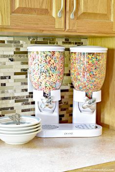 two machines filled with cereal sitting on top of a counter