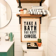 a bathroom with a sign above the toilet that says take a bath you dirty cowgirl