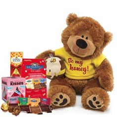 a brown teddy bear sitting next to some chocolates