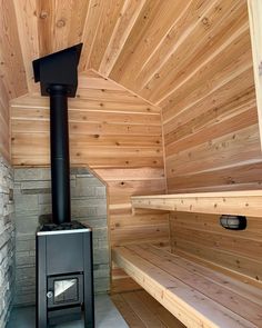 a wood burning stove in the corner of a room with wooden walls and flooring