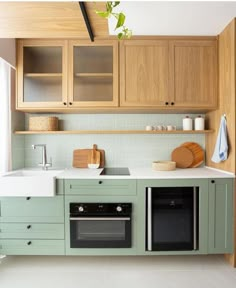 a kitchen with green cabinets and white counter tops