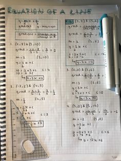 a notebook with some calculations on it and a pen sitting next to the paper that has been written