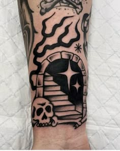 a man's arm with a black and white tattoo design on it, including a skull