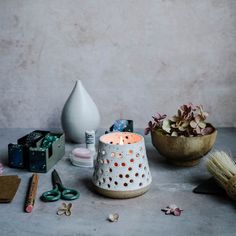 a white candle sitting on top of a table next to some other items and flowers