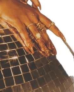 a woman's hand with gold rings on her fingers and bracelets around her wrist