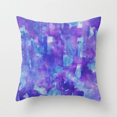 a purple and blue pillow on a white wall