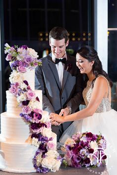 a newly married couple cutting their wedding cake