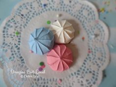 three small umbrellas sitting on top of a doily