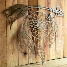 a metal dream catcher hanging on a wooden wall