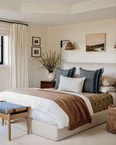 a bedroom with a bed, chair and pictures on the wall