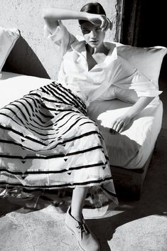 black and white photograph of a woman sitting on a bed