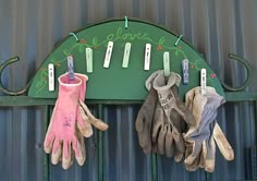 two gloves hanging on a green coat rack