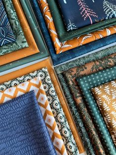 many different types of fabrics are arranged in rows on top of each other, including blue and orange