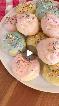 a white plate topped with donuts covered in frosting and sprinkles