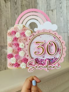 someone is holding up a pink and white birthday card with the number 50 on it