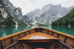 the bow of a boat on a lake with mountains in the background