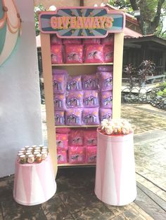 there is a pink candy vending machine with lots of candies in front of it