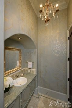 a bathroom with a chandelier and marble counter tops