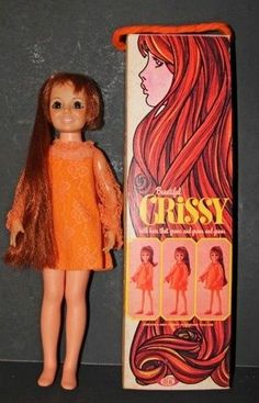 a doll with long hair standing next to a box for the crissy dolls