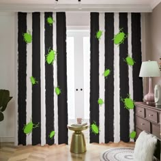 a living room with black and white striped curtains, green bugs on the window curtain