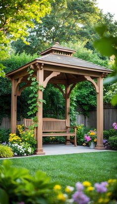 a wooden gazebo surrounded by flowers and greenery